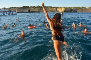 Rapariga a saltar para o mar durante uma festa num barco em Portimão