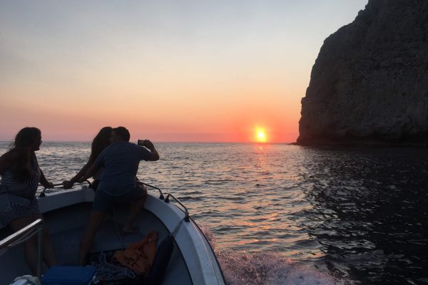 People on a boat watching the sunset in Sesimbra