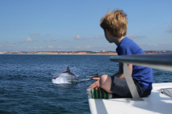 Kid on a boat watching wild dolphins in Vilamoura