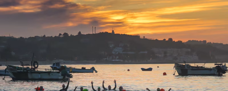 Group of swimmers in Cascais at sunset