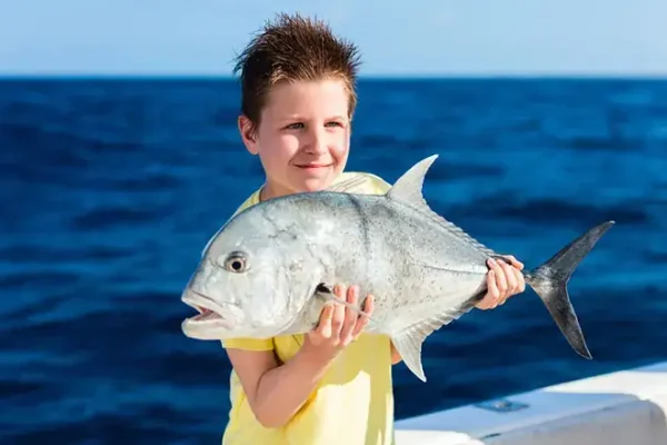 Boy with a fish on a reef fishing tour in Vilamoura