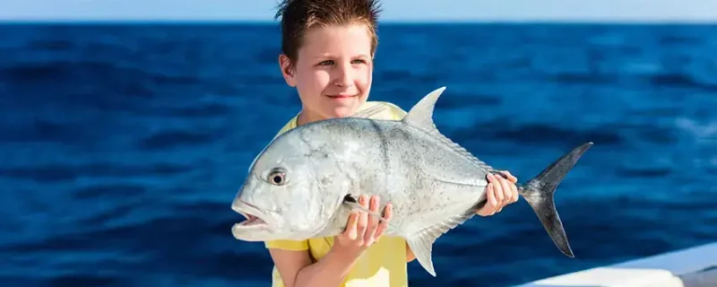 Boy with a fish on a reef fishing tour in Vilamoura