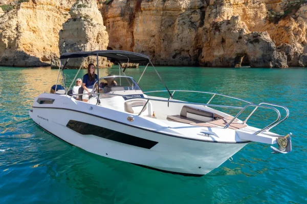 The white Karnic SL701 private boat 'Snowwhite' at anchor near the cliffs of Lagos, Algarve.